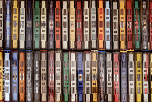 a collection of vintage cassette tapes lined up neatly, showcasing a variety of colored plastic cases