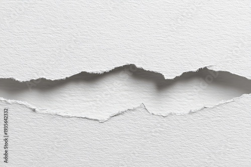 Close-up of ripped white paper, showing jagged edges and shadow