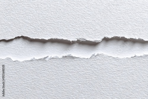 Close-up of ripped white paper, showing the textured edges and void created