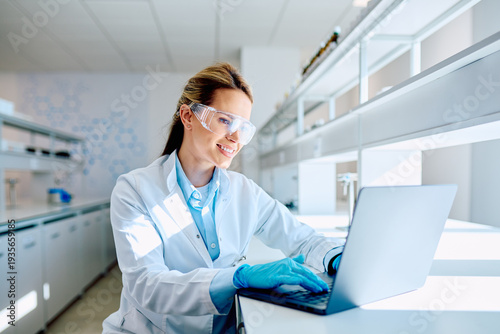 Foto Young female scientist wearing lab coat, safety glasses, and gloves, working on