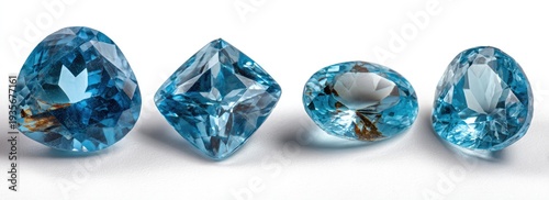 Four brilliant-cut blue gemstones of various shapes, placed horizontally on a white surface