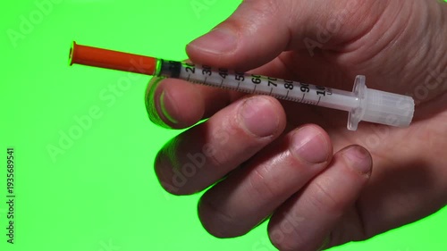 Diabetes treatment.
A person with diabetes holds an insulin syringe in his hand against an isolated background.