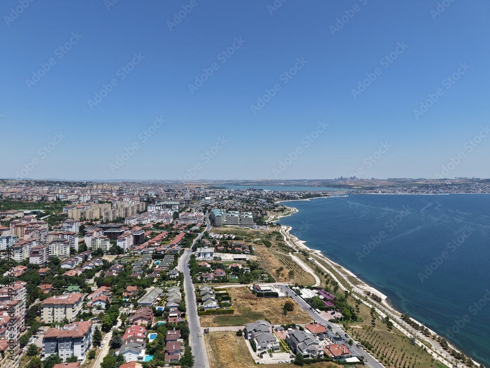 Fototapeta premium Aerial Panoramic View of Coastal Residential Neighborhood and Blue Sea Horizon