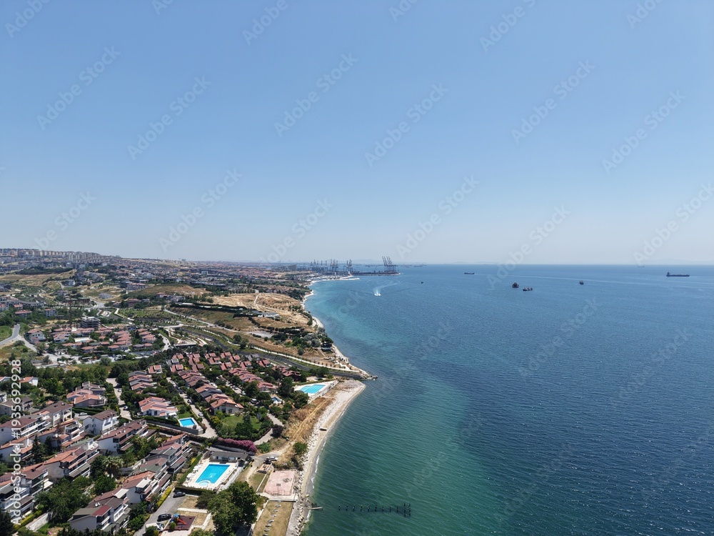 Fototapeta premium Aerial Panoramic View of Coastal Residential Neighborhood and Blue Sea Horizon