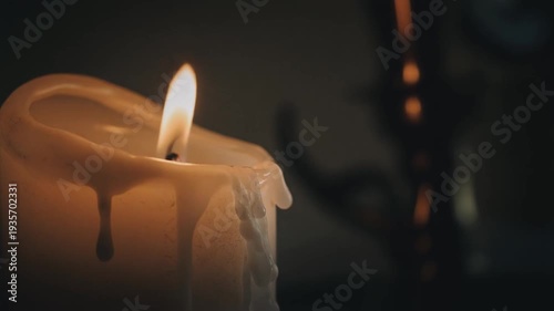 Candle Burning Brightly with Dripping Wax in a Dimly Lit Room