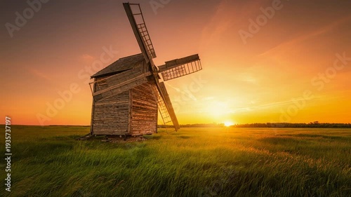 Windmill in a Golden Hour Sunset over a Green Field