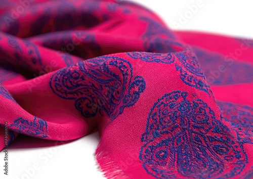 Folded bright pink fabric with ornate blue paisley design, corner detail focus