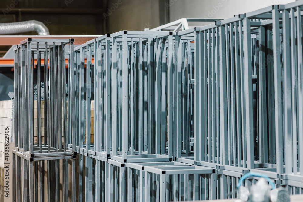 Obraz premium Large batch of finished grey metal frames and steel structures stacked in an industrial factory.
