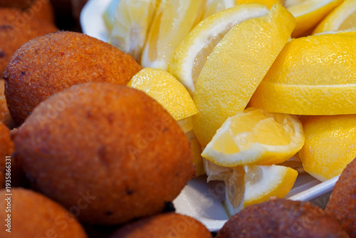 Close-up of traditional Turkish Kibbeh (Icli Kofte) served with fresh sliced lemons, showcasing the crispy texture and authentic culinary presentation