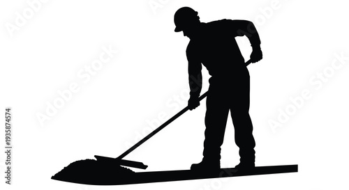 A dark silhouette of a man using a long handled tool to sweep material on a flat surface silhouette