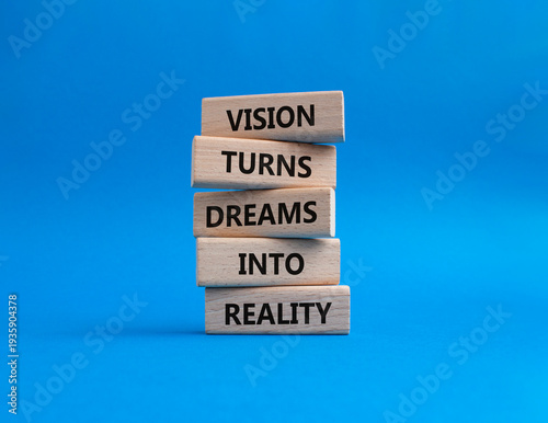 Vision symbol. Wooden blocks with words Vision Turns Dreams Into Reality. Beautiful blue background. Business and Vision concept. Copy space