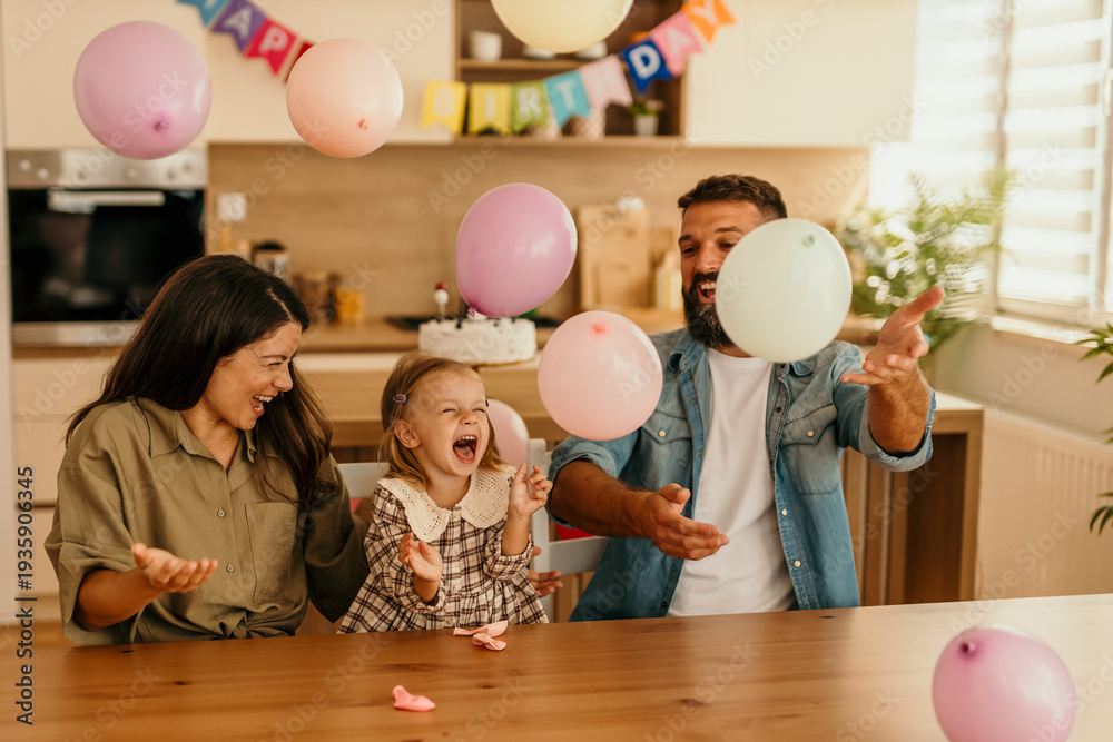 Fototapeta premium Family celebrating birthday with daughter and balloons