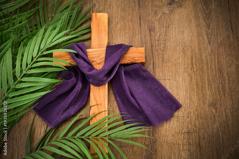 Naklejka premium Wooden cross with purple cloth and palm fronds