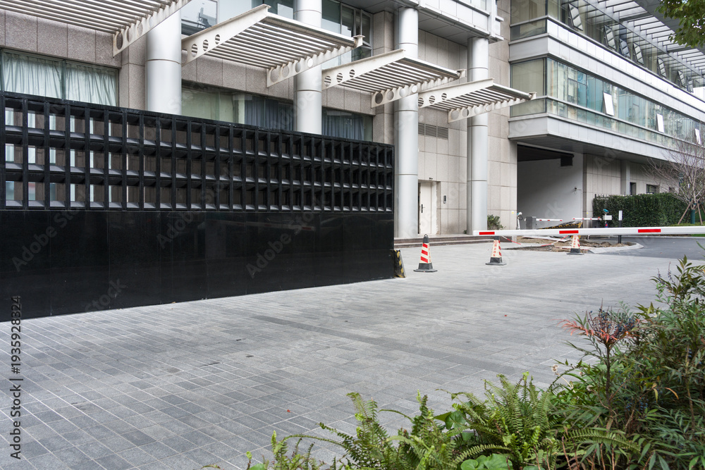 Fototapeta premium Modern building entrance with black grid fence and architectural details in urban setting