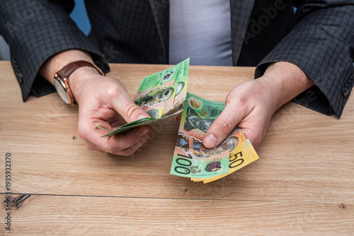 Close up of Man in Suit Counting Australian Dollar Currency for Investment and Wealth Strategy
