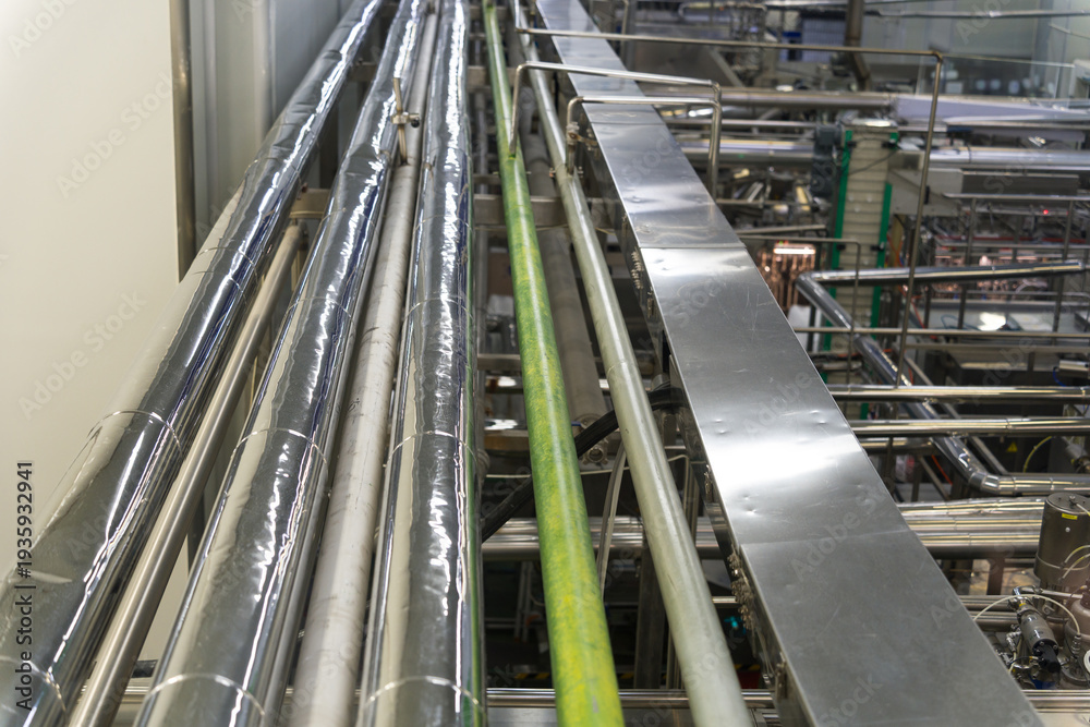 Obraz premium Industrial factory interior featuring metal pipelines and conveyor belt systems
