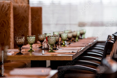 Stylish table setting. Glass glasses and cutlery on a wooden table. A table set up in a restaurant. Wedding service, a buffet at a dining table. A birthday party or a festive event.