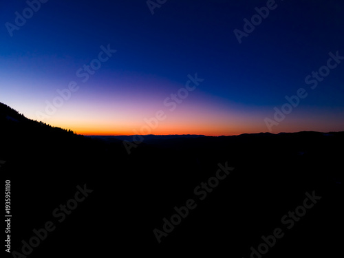 Foto Colorful sky at sunset over mountains with clear horizon and fading light in the