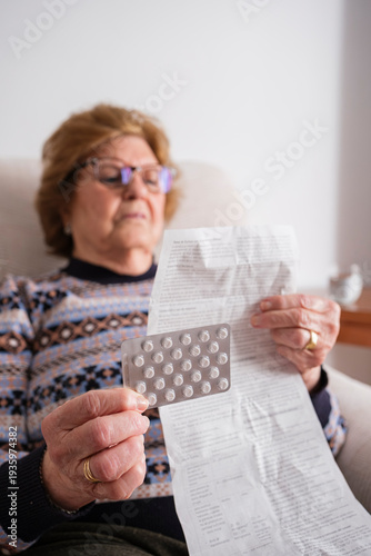 An elderly woman reading a medicine leaflet.