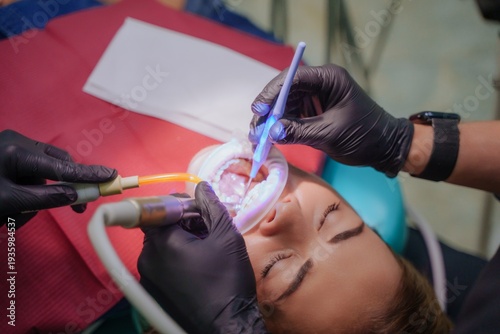 The dentist administers anesthesia to the patient. Dental treatment in a private medical clinic. The patient is injected with the drug from a syringe into the gum.