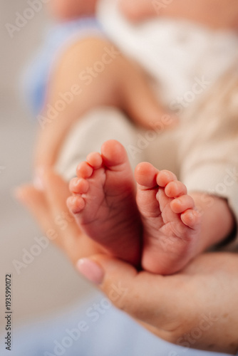 Newborn baby feet in parent hands close-up