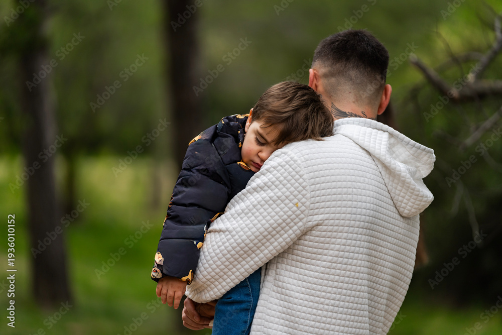 Fototapeta premium Parent carrying sleeping child, showing comfort and security