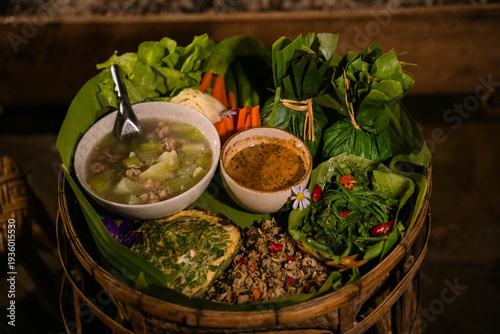 Tableau sur toile Traditional Akha tribal khantoke food set served in a bamboo tray with fresh vegetables, chili dip, soup and local northern Thai dishes