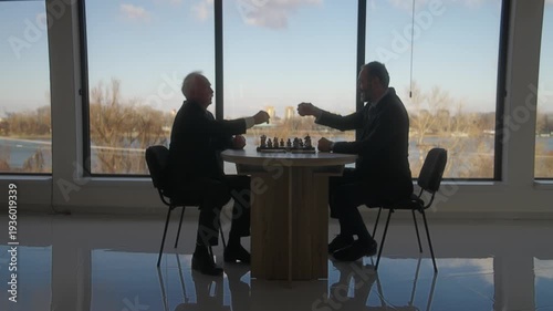 Middle Aged and Senior Businessmen Playing Chess for money in Office