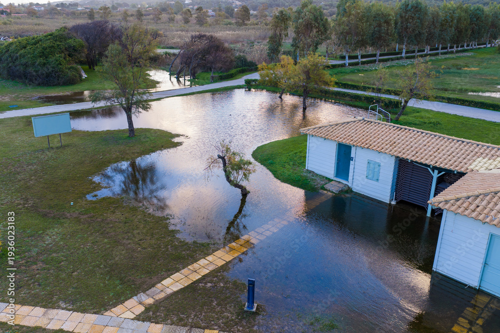 Obraz premium Aerial view of a flooded resort park in Corfu, Greece, showing submerged pathways and small buildings