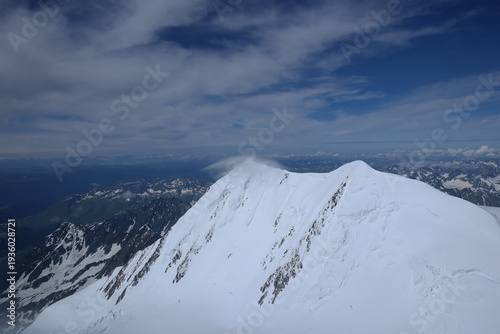 Tranquil Lake With Lush Green Forest, Snow-Capped Mountain, Blue Sky And White Clouds