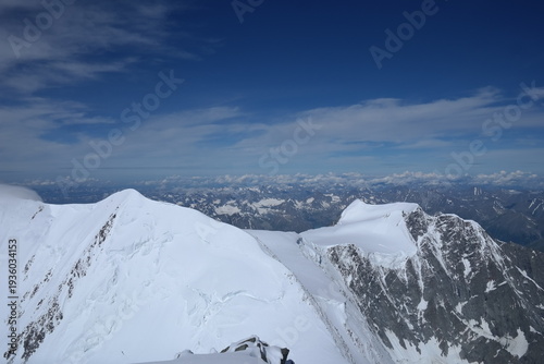 Tranquil Lake With Lush Green Forest, Snow-Capped Mountain, Blue Sky And White Clouds
