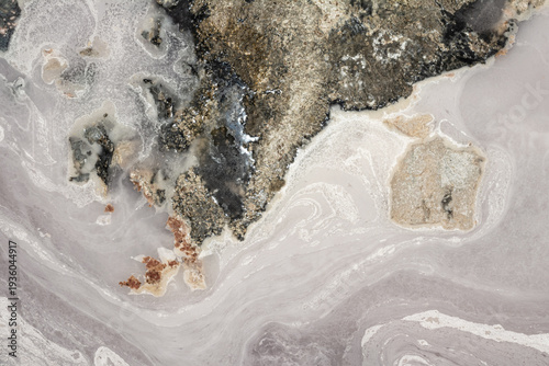 Imitation Satellite view of a desolate, oil-polluted shoreline, dark patches, swirling contamination, stark contrasts of black, gray, and white, a grim depiction of environmental neglect and pollution