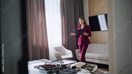 Business lady rehearsing speech in hotel room after arrival. Elegant woman