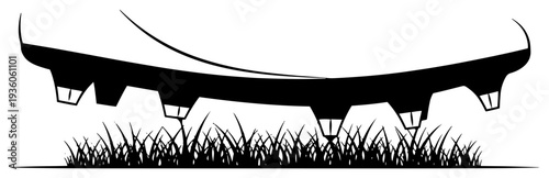 Silhouette of a football boot sole with studs on grass field