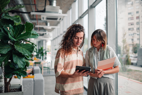 Wallpaper Mural Coworkers collaborating on tablet in modern office Torontodigital.ca