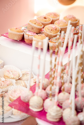Elegant pink sweet table setup for a birthday celebration featuring beautifully decorated cake pops and delicate desserts in soft pastel tones. 