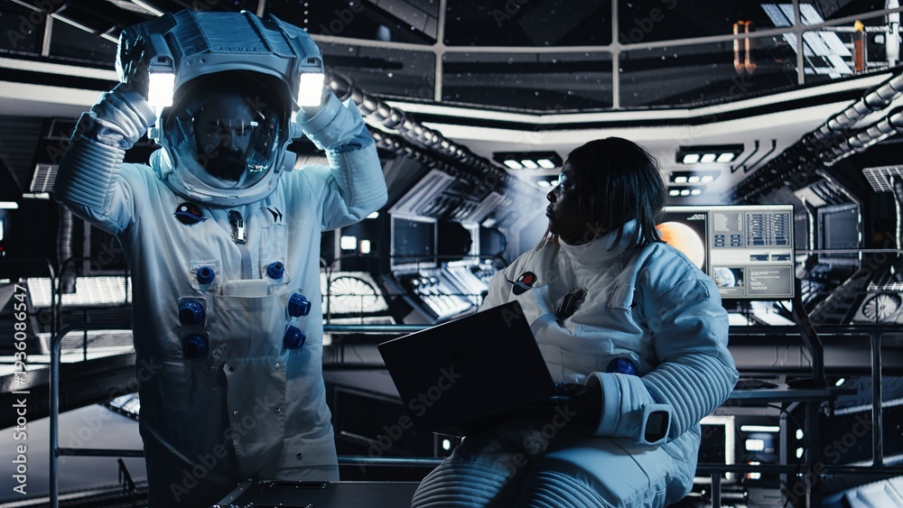 Fototapeta premium Team of astronauts running data analysis on laptop before stepping out outside space station. Teamworking cosmonaut verifying mission parameters on notebook after landing on planet
