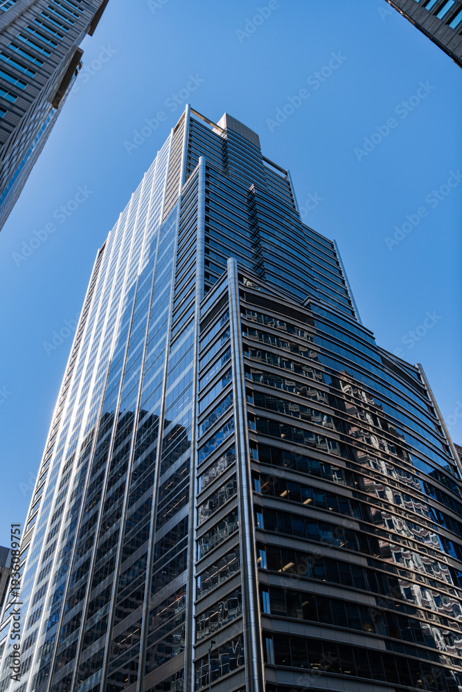 Obraz premium Business building. Glass building. Business city. City architecture. Modern glass building. Reflective glass architecture. Architecture in business district. Financial district. Building architecture