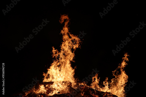 Ein großes brennendes Feuer aus Baumstämmen, freigestellt mit schwarzem Hintergrund