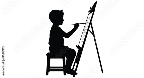 Young artist intently painting at an easel a striking silhouette