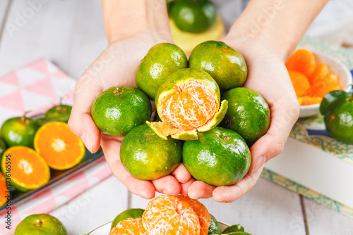 Quadro su tela Fresh Small Sweet Citrus Fruits from Guangxi China Held in Hands Showing Orange