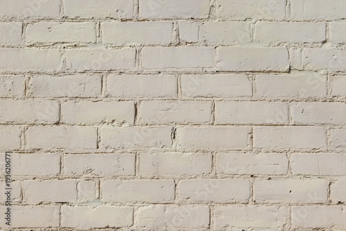  A close-up of an old exterior wall of a building with bricks. Construction material with white bricks. Background or backdrop with white and grey colors. Painting on exterior bricks.