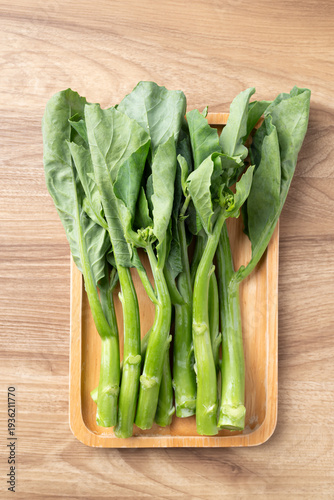 Photos Fresh Chinese kale or Chinese broccoli (Gai Lan) on wooden tray, prepared for co