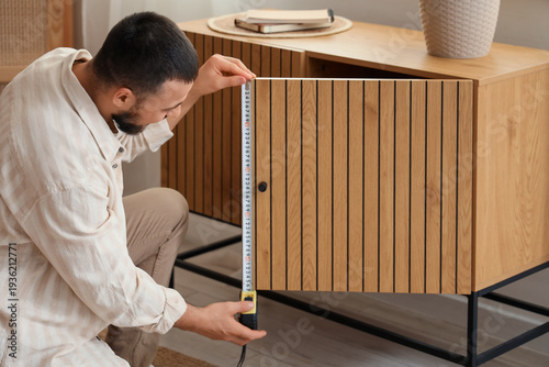 Young man measuring chest o...
