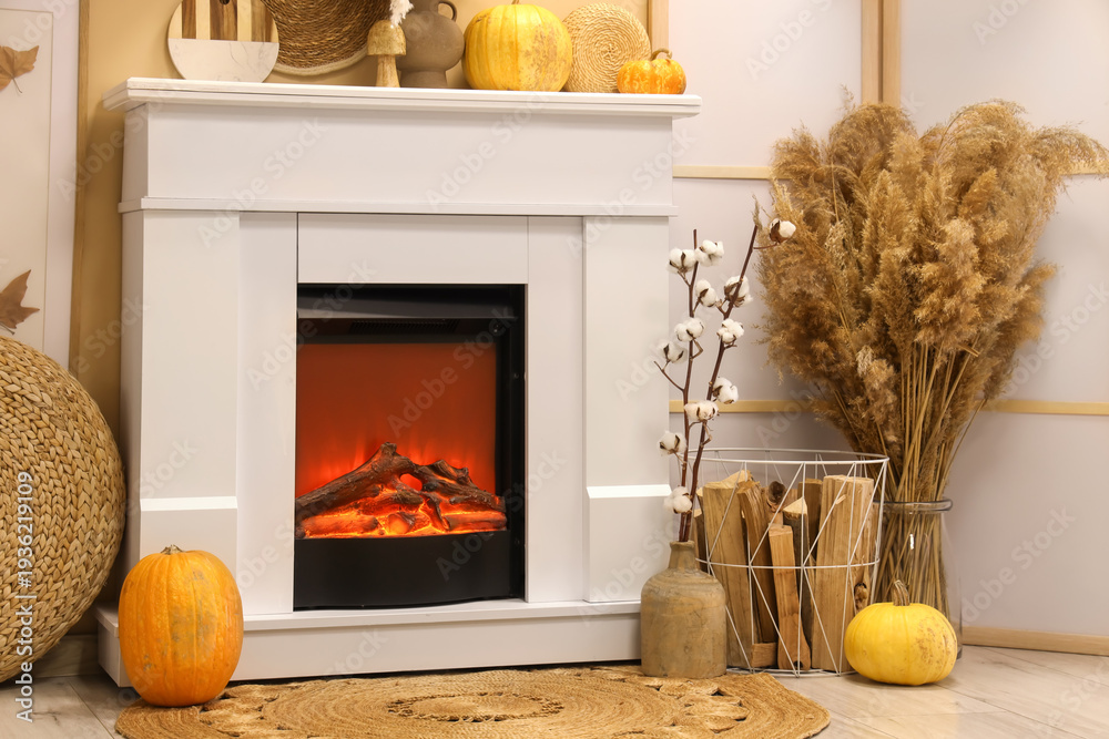 Obraz premium Interior of modern living room with fireplace, folding screen and pumpkins