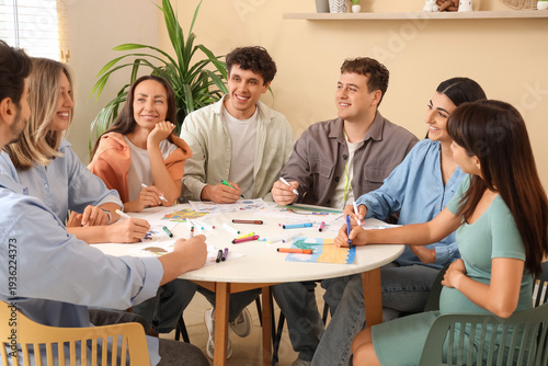 Group of people drawing at table during art therapy