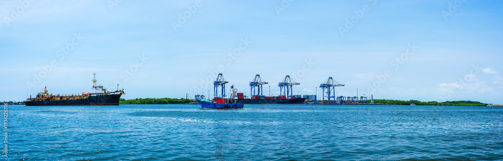 Naklejka premium Panoramic sea view, cargo container ship and cityscapes of Kerala, India.