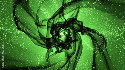 Abstract black liquid forms a dynamic swirling pattern on a vibrant green