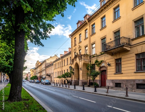 Wallpaper Mural Long street lined with tall buildings in warm hues, with a road and a tree-lined sidewalk, and a blue sky overhead Torontodigital.ca