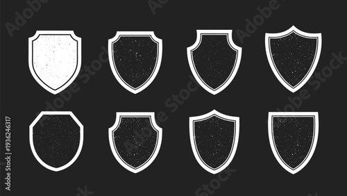 Collection of eight diverse shield silhouettes with a distressed white texture arranged in a grid on a dark grey background for logo design.